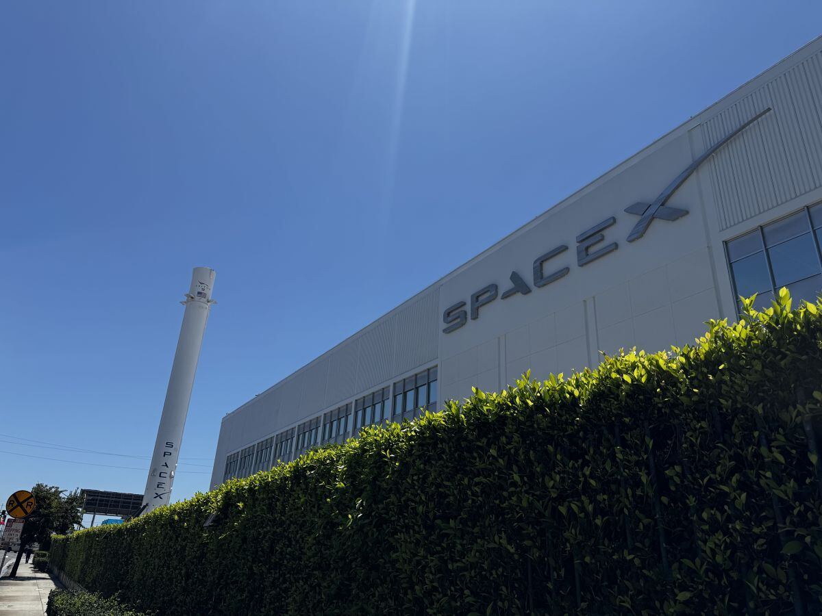 カリフォルニア州ホーソーンにあるスペースXの主要拠点。奥に見えるのは、世界で初めて軌道級ロケットの第1段として垂直着陸・回収に成功した「Falcon 9」のブースター。(撮影:mynt編集部)