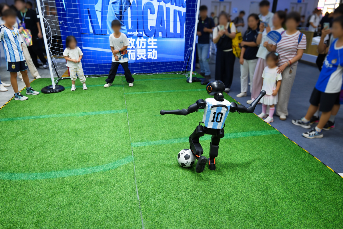観客の目の前でサッカーボールを蹴る人型ロボット